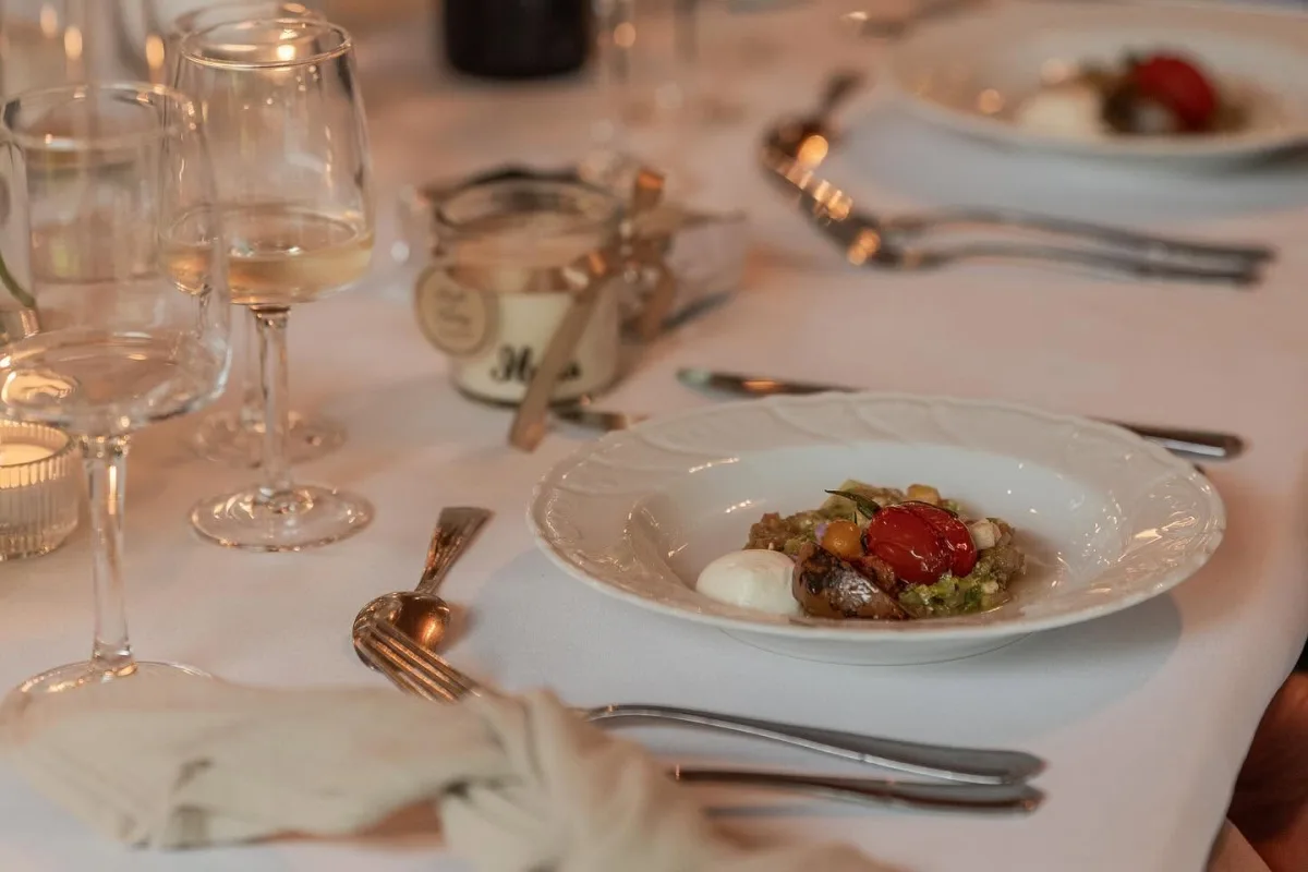 Table dressée en salle de réception avec entrée servie à l'assiette